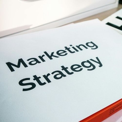 Close-up of a printed document with the words Marketing Strategy in bold on white paper.